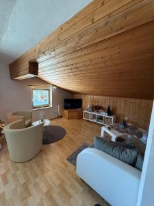 a living room with a white couch and wooden ceilings at Hotel Bergglück in Filzmoos