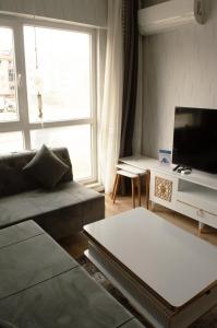 a living room with a couch and a tv at Classic Suite AA7 in Esenyurt