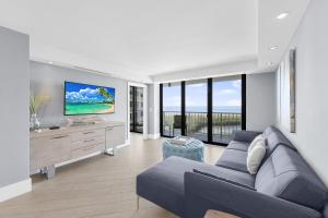 a living room with a couch and a tv at Elegant beachfront condo in private community in Marco Island