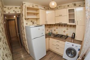 a kitchen with a refrigerator and a washer and dryer at АЛЬ-ТАИР Апартаменты 1-ком в центре in Petropavlovsk