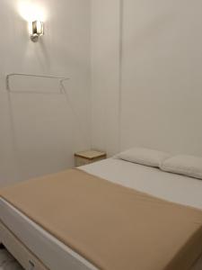a white bedroom with a bed and a light on the wall at Pearl Villa 5 Bedroom Unit 13A in Port Dickson