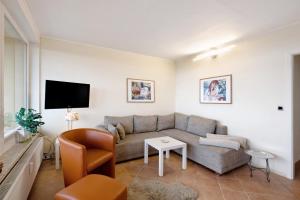a living room with a couch and a tv at Panoramablick über den Oberharz in Braunlage