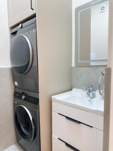 ein Badezimmer mit Waschmaschine und Waschbecken in der Unterkunft В шикарном районе Атырау возле дворца ЦЕНТР АБАЯ New City от аэропорта 3 минуты in Atyrau + 16 Fotos