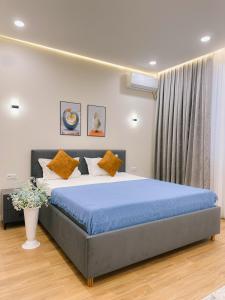 a bedroom with a large bed with a blue blanket at В шикарном районе Атырау возле дворца ЦЕНТР АБАЯ New City от аэропорта 3 минуты in Atyraū