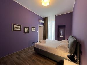 a bedroom with purple walls and a bed at Palazzo Zippitelli Apartments in Bari