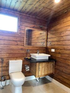 a wooden bathroom with a toilet and a sink at Jironi Resort in Tezpur +15 photos