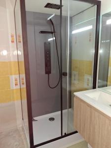 une douche avec un téléphone dans une salle de bain dans l'établissement Appartement avec piscine - La Chaume, à Les Sables-dʼOlonne