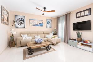 ein Wohnzimmer mit Sofa und Fernseher in der Unterkunft Home2Book Luxury Villa Pool & Terrace, Corralejo in Corralejo