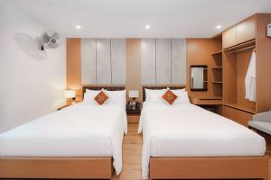 two beds in a hotel room with a television at Lam Anh Hotel 8 Ngoại Giao Đoàn BT3-10 in Hanoi +77 photos