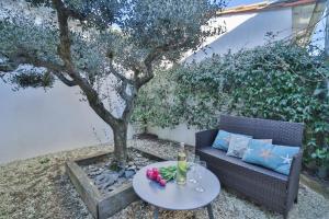 a patio with a table and a couch and a tree at Domaine Rose Tremiere in Rivedoux-Plage