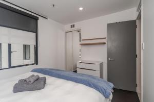 a bedroom with a bed with towels on it at The Terrace CBD Apt for Work & Play in Wellington