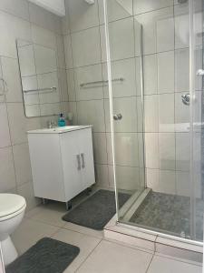 a bathroom with a shower and a toilet at Dassen Cove Self Catering in Plettenberg Bay +34 photos