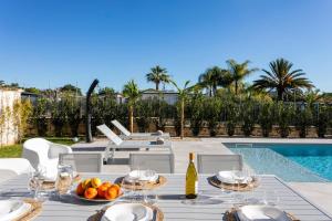 einen Tisch mit einer Obstschale neben einem Pool in der Unterkunft ISULATRAVEL - Villa Nerissa in Pozzallo