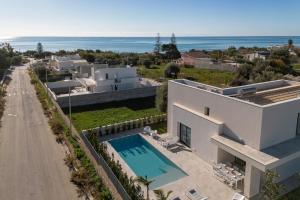 eine Luftaufnahme eines Hauses mit Swimmingpool und dem Meer in der Unterkunft ISULATRAVEL - Villa Nerissa in Pozzallo