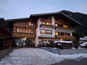 a large wooden building with snow in front of it at Ferienwohnungen Rupertihaus in Flachau