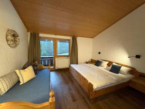 a bedroom with a large bed and a window at Dreimäderlhaus am Berg in Pfronten