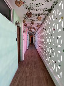 einen Flur eines Zimmers mit einer mit Blättern verzierten Wand in der Unterkunft Puul Suites in Mérida