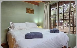 a bedroom with a large white bed with two towels on it at At Kruger's Heartbeat in Marloth Park +25 photos
