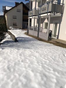a pile of snow in front of a house at Appartment Isabelle Sky in Presseggersee