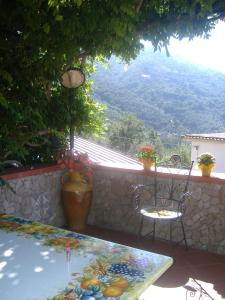 a table and chairs on a patio with a view of a mountain at B&B Villa Ursa Major in Vico Equense +6 photos