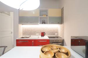 a kitchen with red cabinets and a bowl on the counter at PrimoPiano - Sant' Arnaldo in Milan +37 photos
