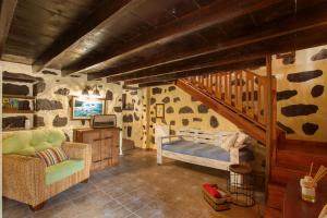 a room with a staircase and a couch and a chair at Ancana in Vega de San Mateo