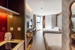 a small hotel room with a bed and a sink at Seascape Mandala Resort Phan Thiết in Mui Ne