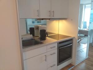 a kitchen with white cabinets and a sink at Apartment Ostseeblick 131 in Timmendorfer Strand
