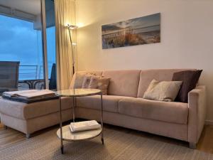 a living room with a couch and a glass table at Apartment Ostseeblick 131 in Timmendorfer Strand +30 photos