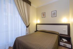 a bedroom with a bed and a large window at Hotel Boccascena in Genoa