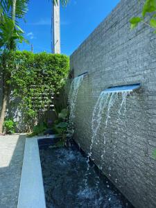 a brick wall with a water fountain on it at Ploy Mountain View Pool Villa in Ban Thai Thai