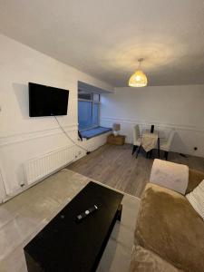 a living room with a couch and a tv on the wall at Northgate House in Chester