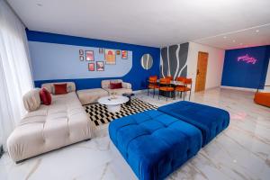 ein Wohnzimmer mit einem Sofa und einer blauen Wand in der Unterkunft The lodge Residence by Goodmove - Hay Riad in Rabat