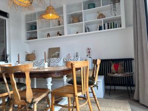 a dining room with a wooden table and chairs at Villa Vieilles Vignes vue mer in Billiers