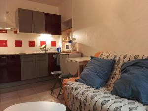 a living room with a couch and a kitchen at Studio 1 in Vaison-la-Romaine