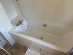 a white bath tub with a faucet in a bathroom at Villa Vieilles Vignes vue mer in Billiers