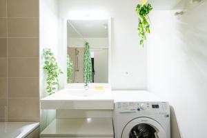 a bathroom with a washing machine and a sink at Appartement tout équipé proche Paris - Stade de France in Épinay-sur-Seine