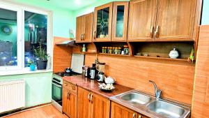 una cucina con mobili in legno e un lavello di Private Room in Tbilisi with LIGHT & LOVE Energy! a Tbilisi City
