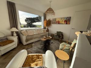 a living room with a couch and a table at Villa Vieilles Vignes vue mer in Billiers +37 photos