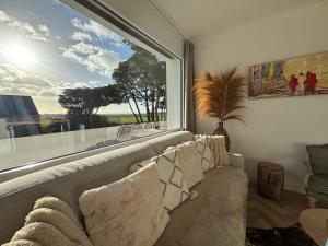 a living room with a couch and a large window at Villa Vieilles Vignes vue mer in Billiers