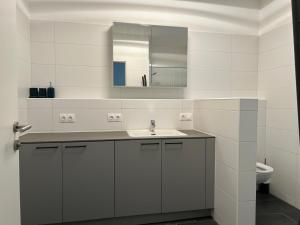 Un baño blanco con lavabo y espejo. en Apartment Elena, en Hinterstoder 35 fotos más