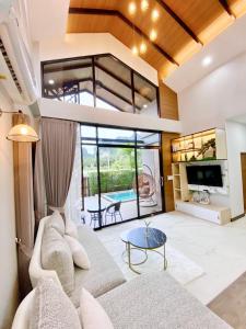 a living room with a couch and a table at Ploy Mountain View Pool Villa in Ban Thai Thai