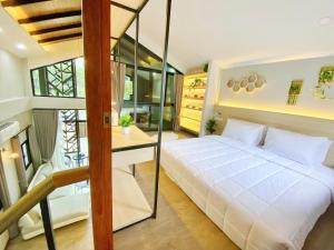a bedroom with a large white bed and a desk at Ploy Mountain View Pool Villa in Ban Thai Thai