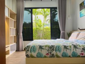 una camera da letto con un letto e una grande finestra di Ploy Mountain View Pool Villa a Ban Thai Thai