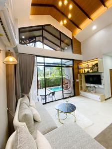 un soggiorno con un divano e un tavolo di Ploy Mountain View Pool Villa a Ban Thai Thai