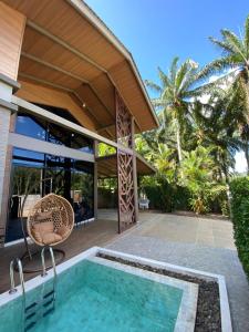 a house with a swimming pool in front of a house at Ploy Mountain View Pool Villa in Ban Thai Thai