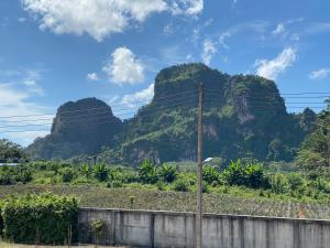 a view of three large mountains with a fence at Ploy Mountain View Pool Villa in Ban Thai Thai
