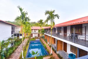 莫尔吉姆Fabhotel Morjim Bliss - 500M From Morjim Beach的带游泳池的建筑物的鸟瞰图