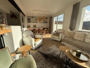 a living room with a couch and chairs and a table at Villa Vieilles Vignes vue mer in Billiers