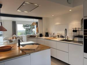 a kitchen with white cabinets and a counter top at Villa Vieilles Vignes vue mer in Billiers